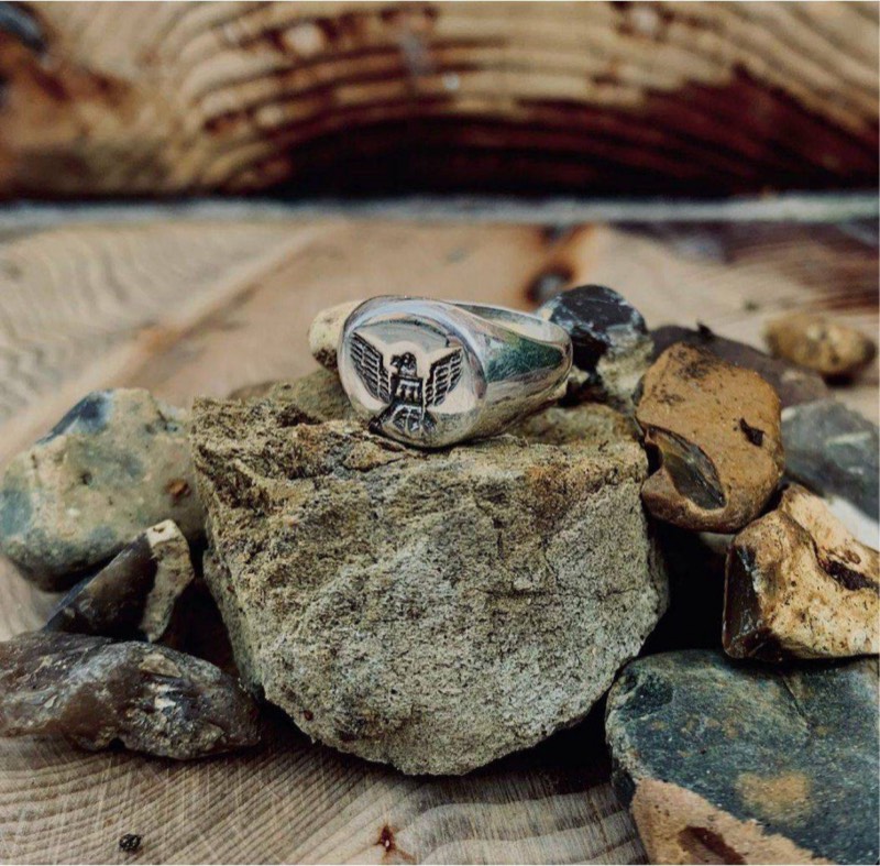 Hand-made silver signet ring resting on stone